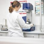 Mitarbeiterin der Palmen Apotheke Ottobrunn stellt im Apothekenlabor mit dem Topitec individuelle Rezepturen für Patientinnen und Patienten her.